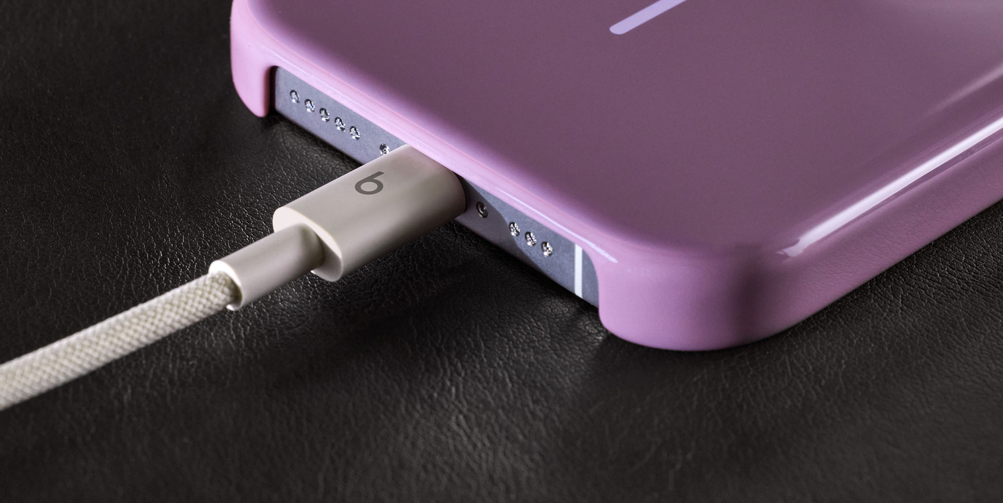 一人将 Beats USB-A 转 USB-C 编织连接线插入 iPhone。