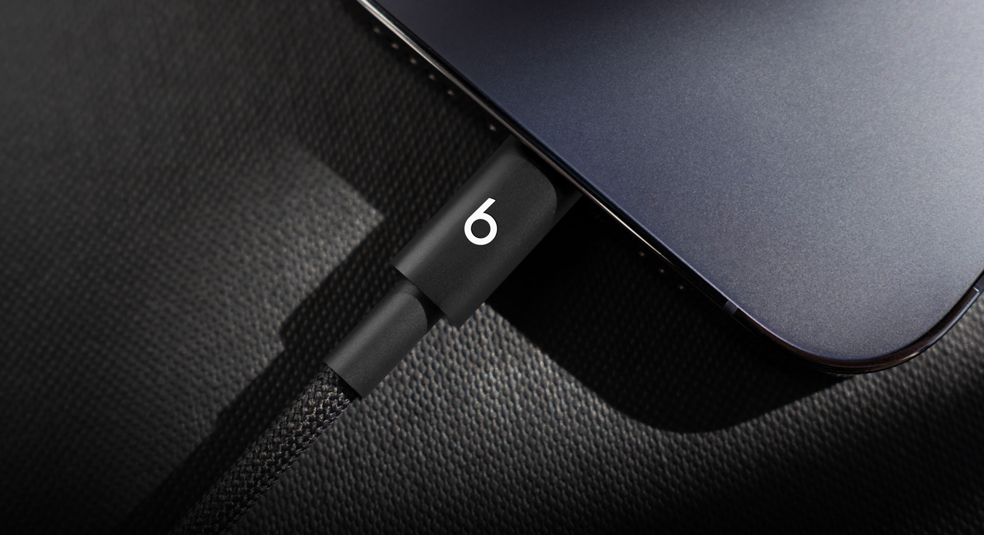 一人将 Beats USB-C 转 USB-C 编织连接线插入 iPhone。