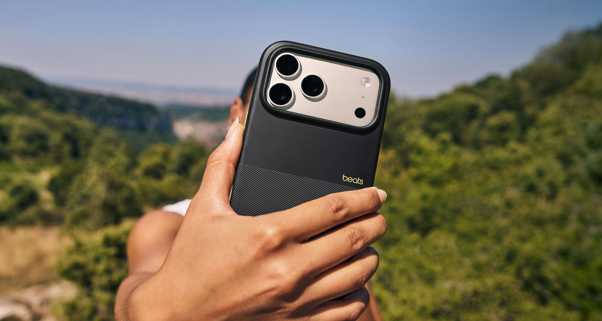 A person holding the Beats iPhone 17 Rugged Case with MagSafe and Camera Control in Everest Black showing the textured matte exterior to demonstrate it’s no-slip grip.