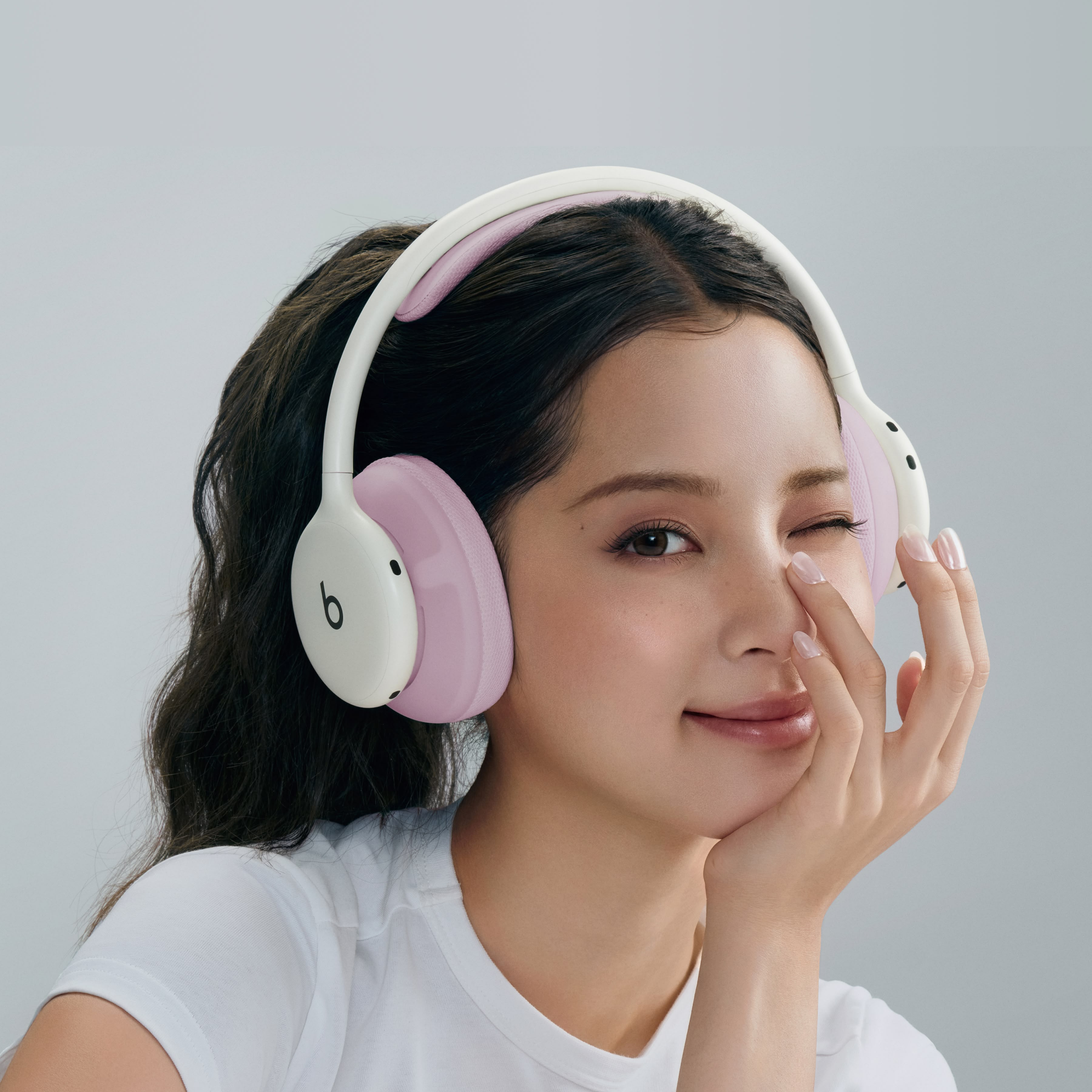 一人戴着云白色 Beats 360，耳机配有粉色机能编织头梁软垫和耳罩